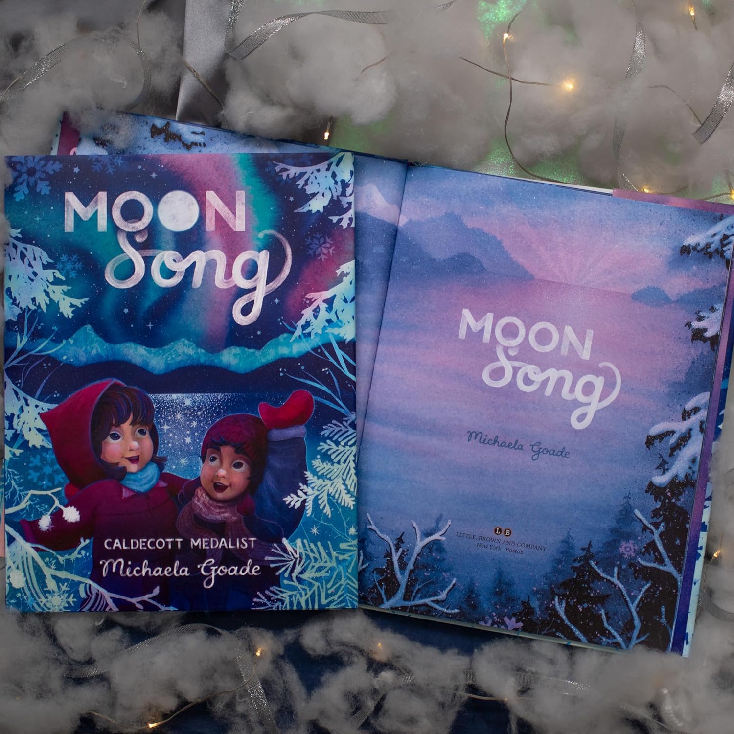Two copies of 'Moon Song' book with a snowy background