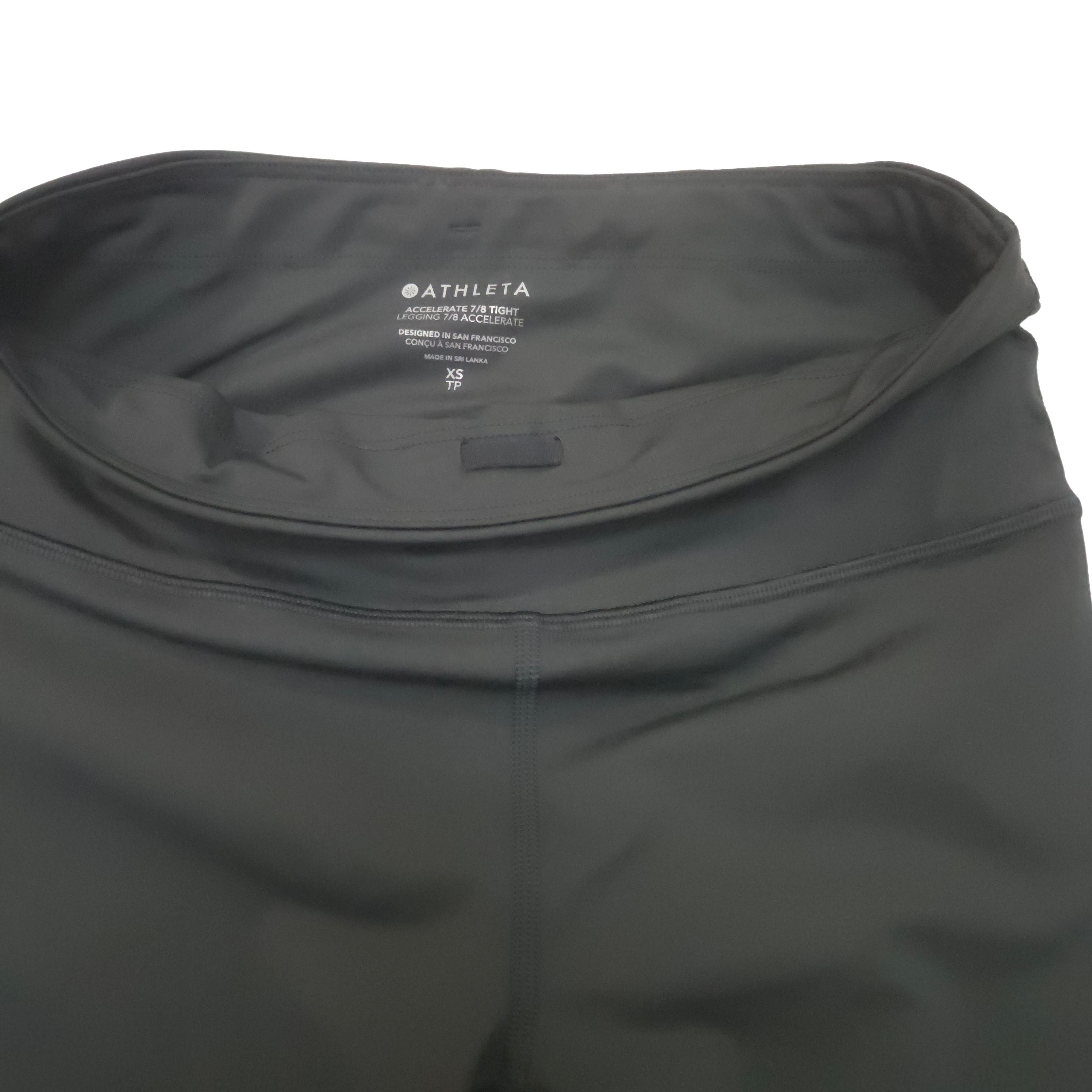 Close-up of a dark black athletic leggings waistband with the ATHLETA brand name printed inside the waistband.
