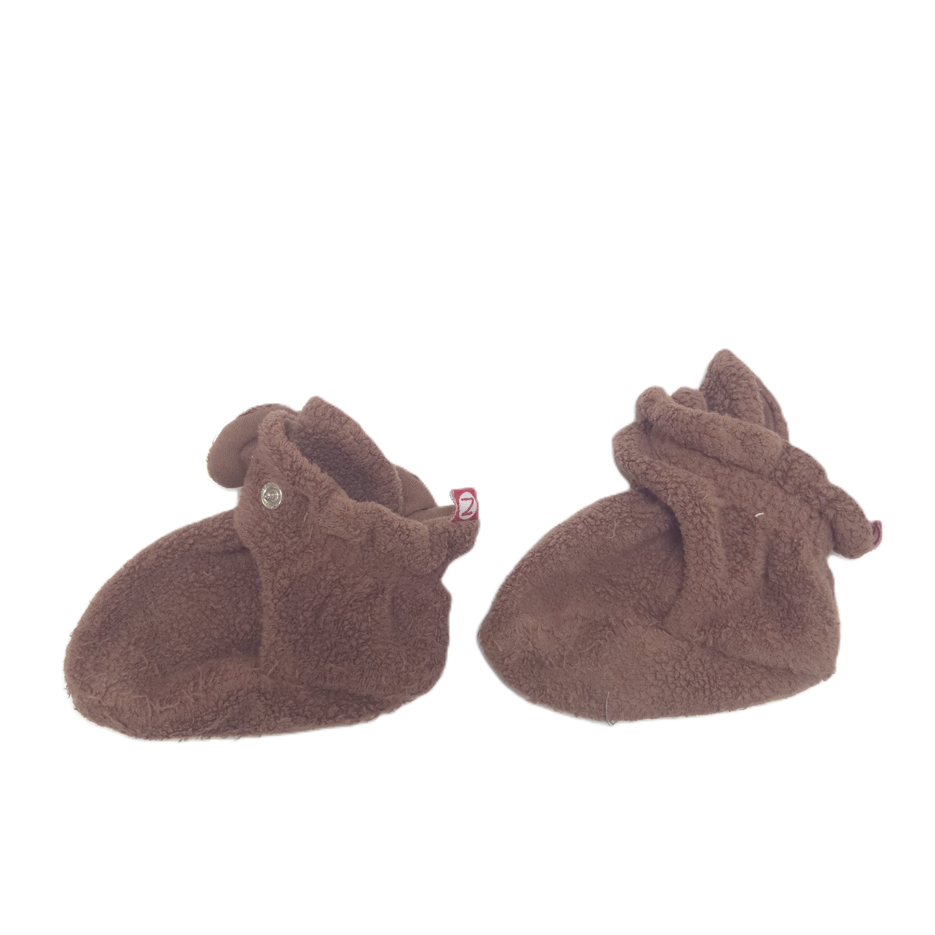 A pair of plush brown baby booties with snaps another side