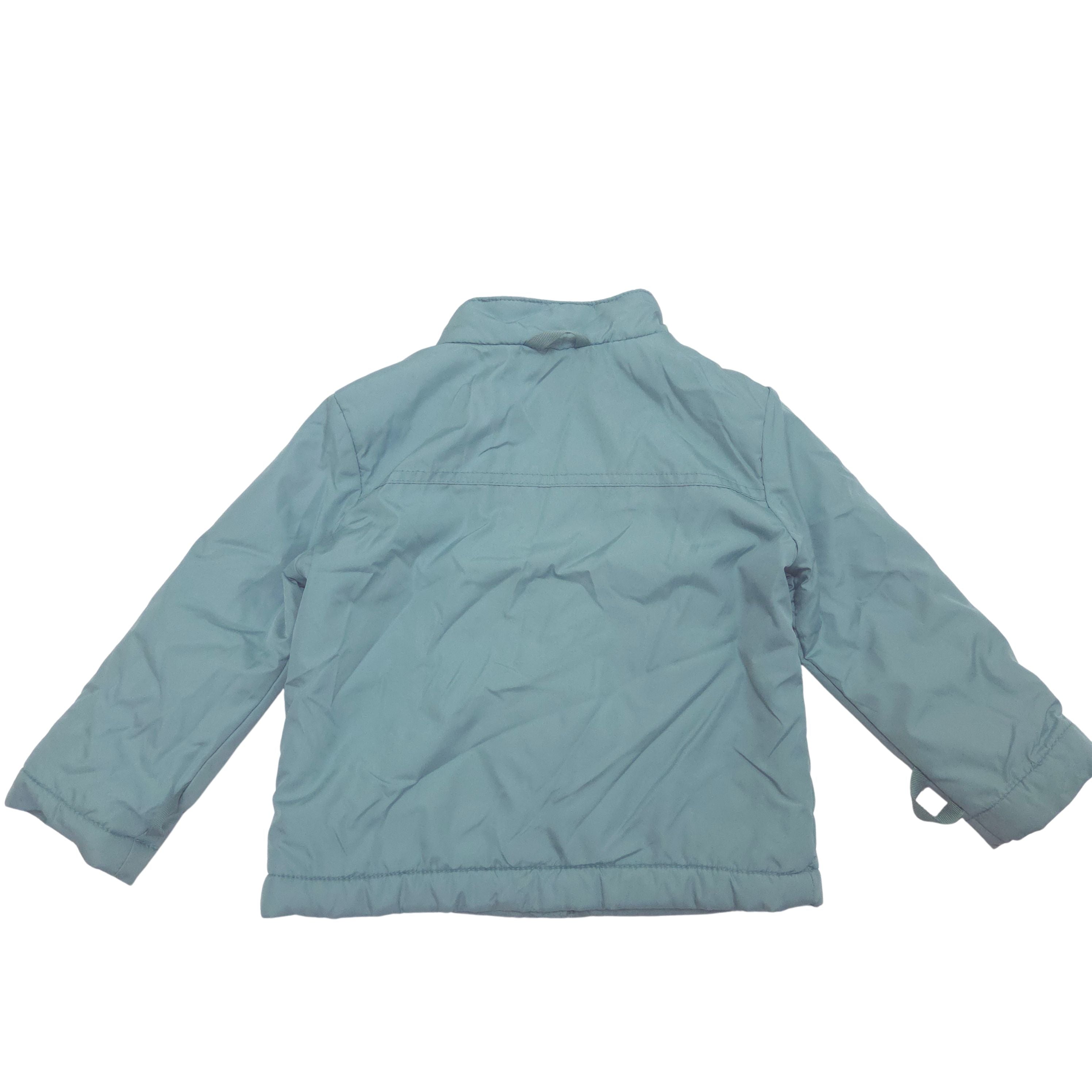 A light blue-gray quilted jacket shown from the back, laid flat against a solid white background.