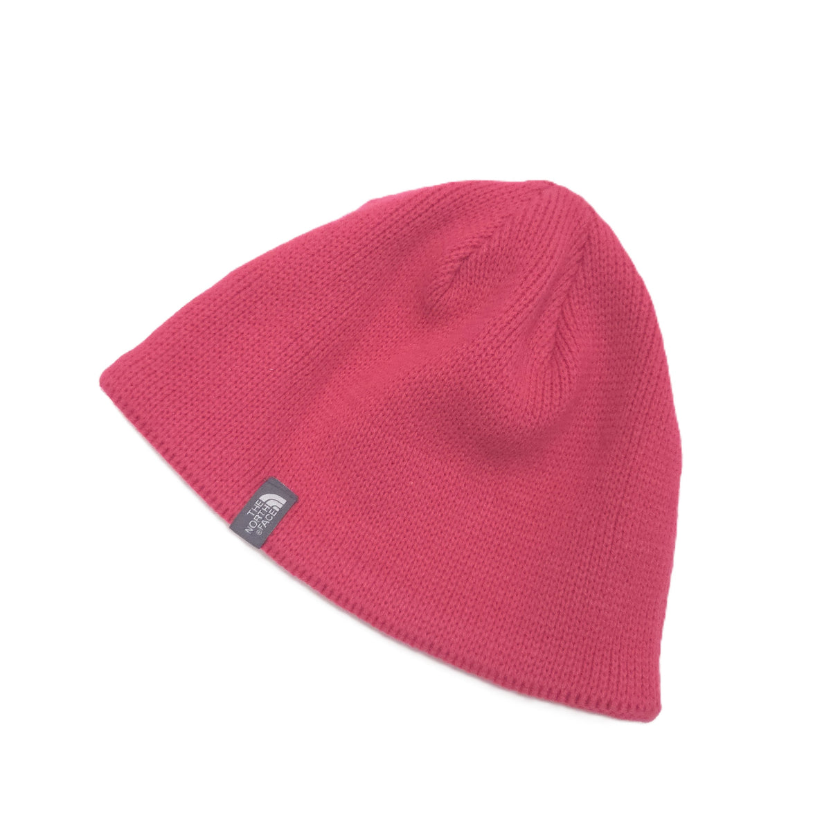 A pink knit beanie hat with a small black and white The North Face logo patch on the side, displayed on a clean white background.