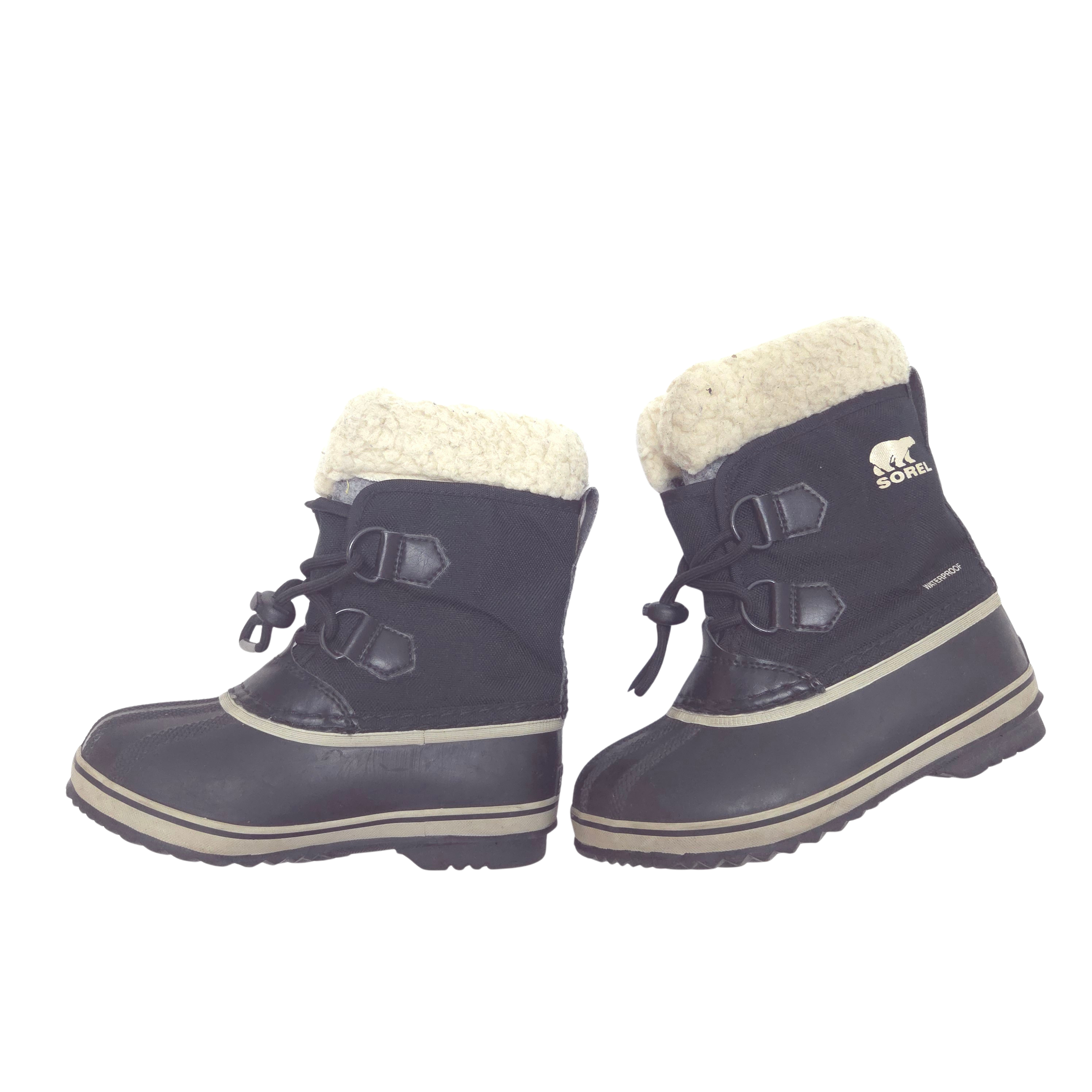 A pair of Sorel kids' winter boots in black with a cream sherpa lining and beige trim, shown against a plain white background.