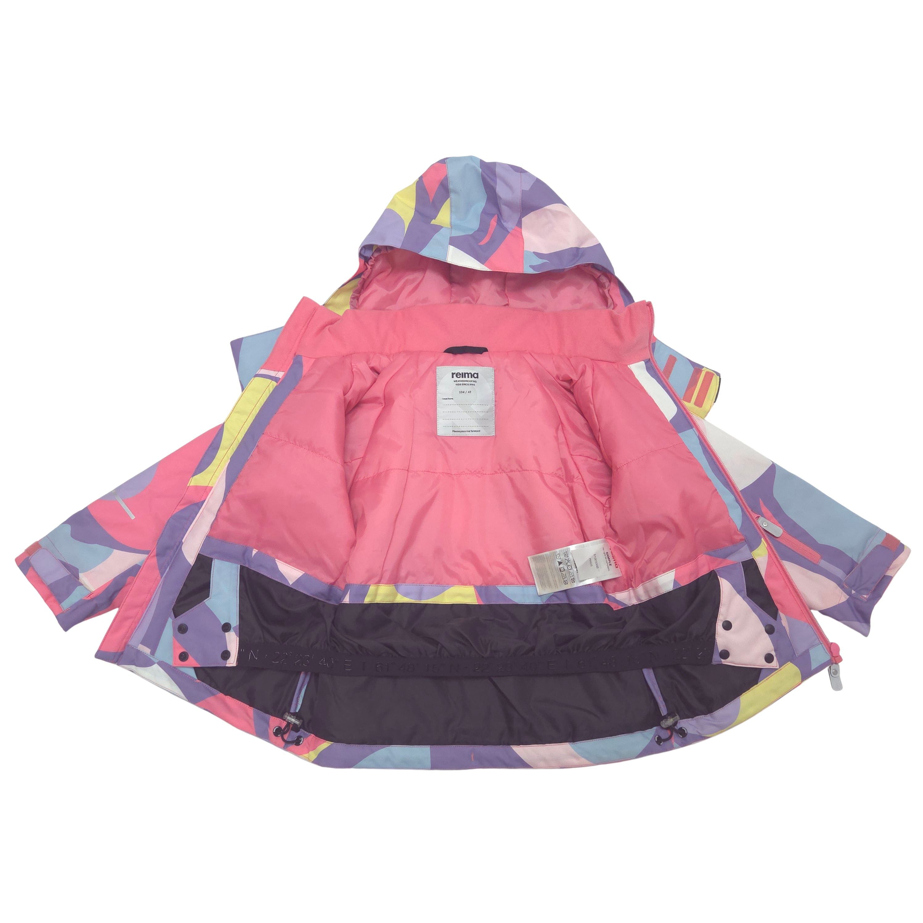 A children's hooded winter jacket shown open against a white background, featuring a bright pink interior lining and a multicolor geometric pattern on the exterior with pink, purple, blue, yellow, and white shapes.