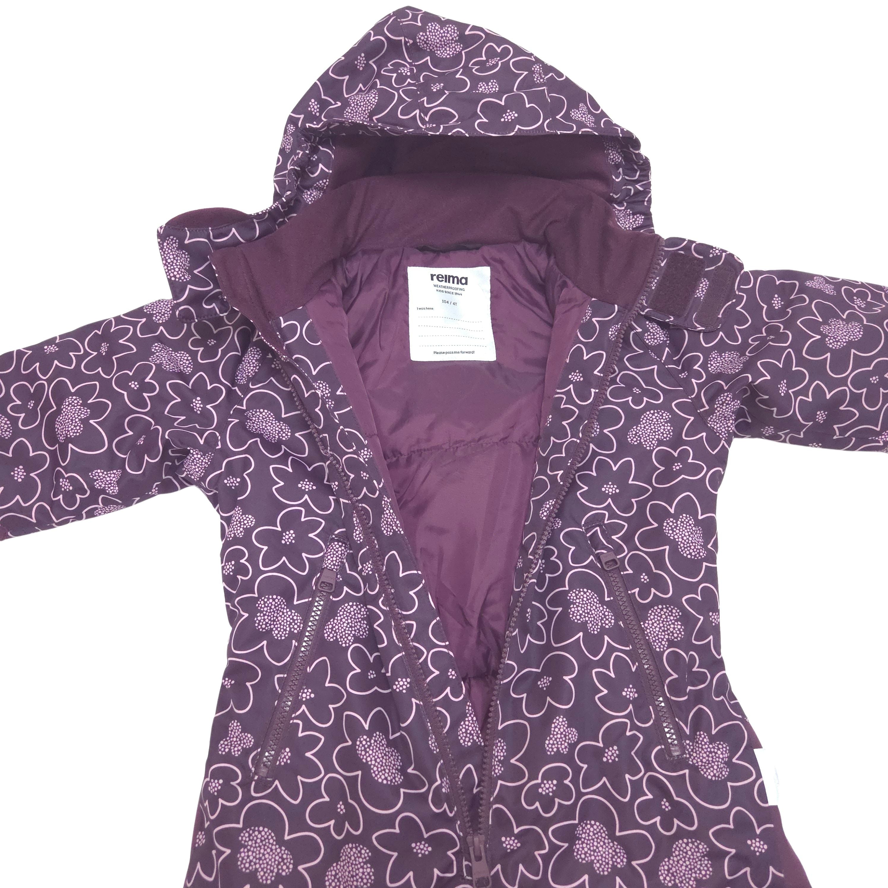 A purple hooded winter jacket with a white floral pattern, laid flat against a white background. The brand label 'reima' is visible inside the collar.