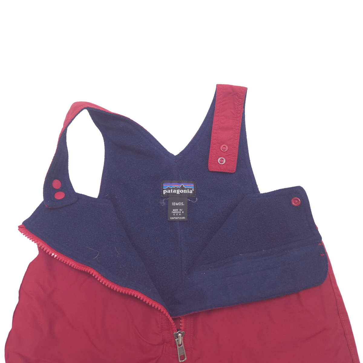 A Patagonia snow pants shown from the inside, featuring a navy blue fleece bib panel with a red zipper and red trim, and a red outer shell.