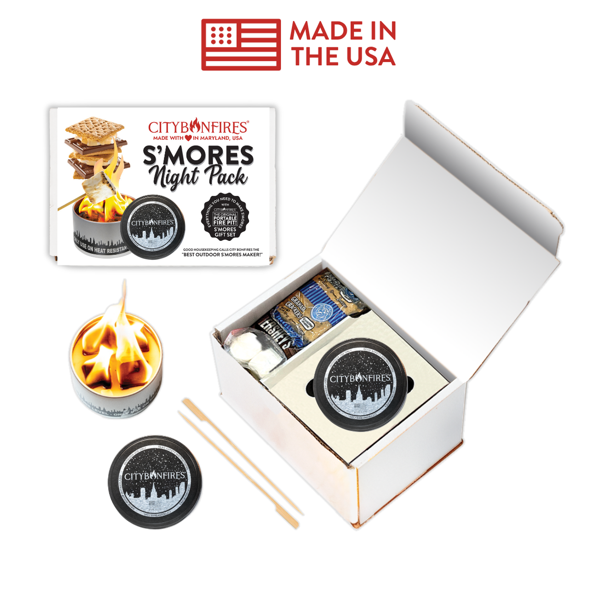 City on Fires S'mores Night Pack shown with its retail box, an open white kit box containing a small tin candle, a round tin, wooden sticks, and a separate lid on a white background. A red 'MADE IN THE USA' graphic appears at the top.