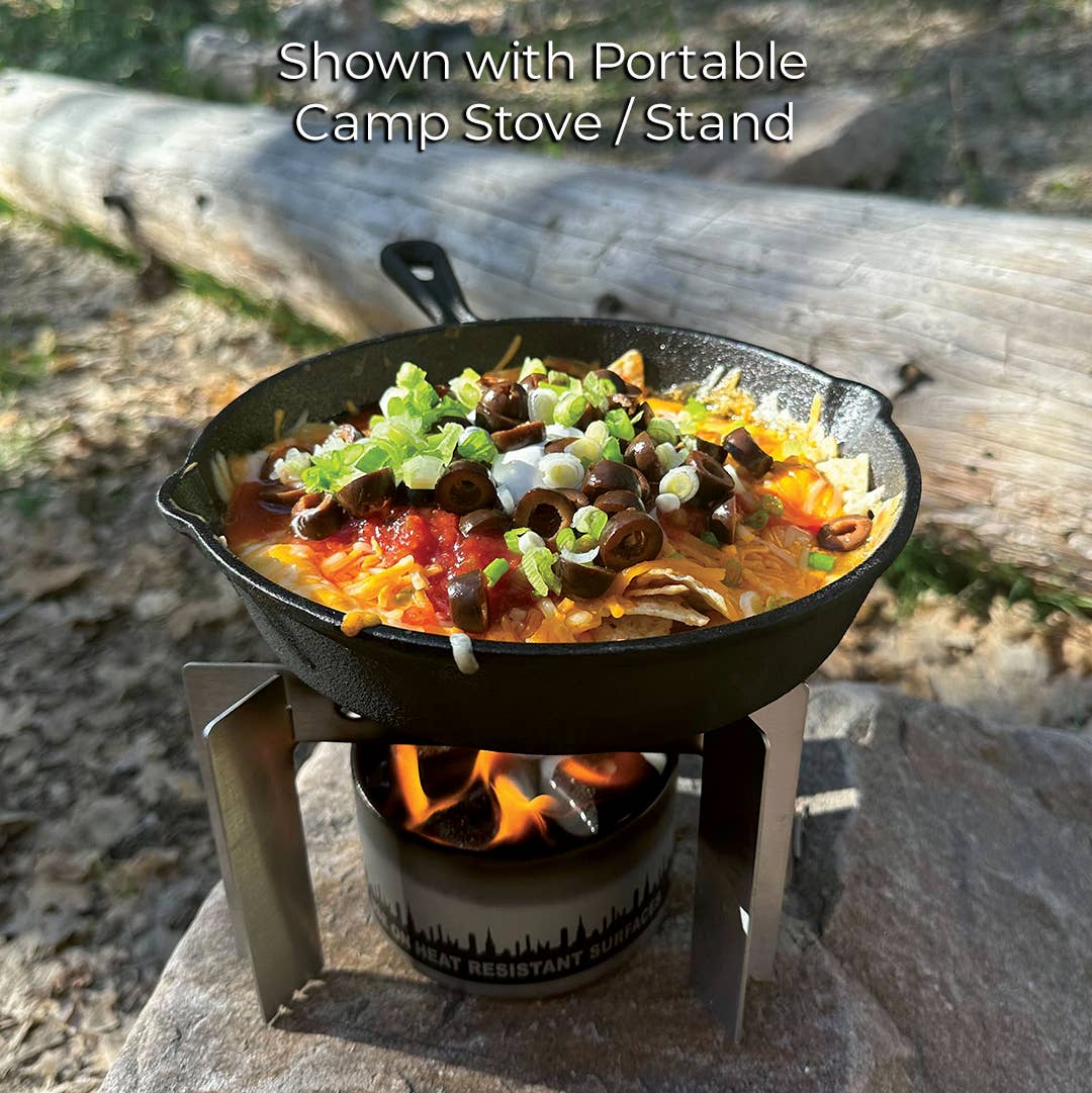 Cast iron skillet with food on a portable camp stove outdoors