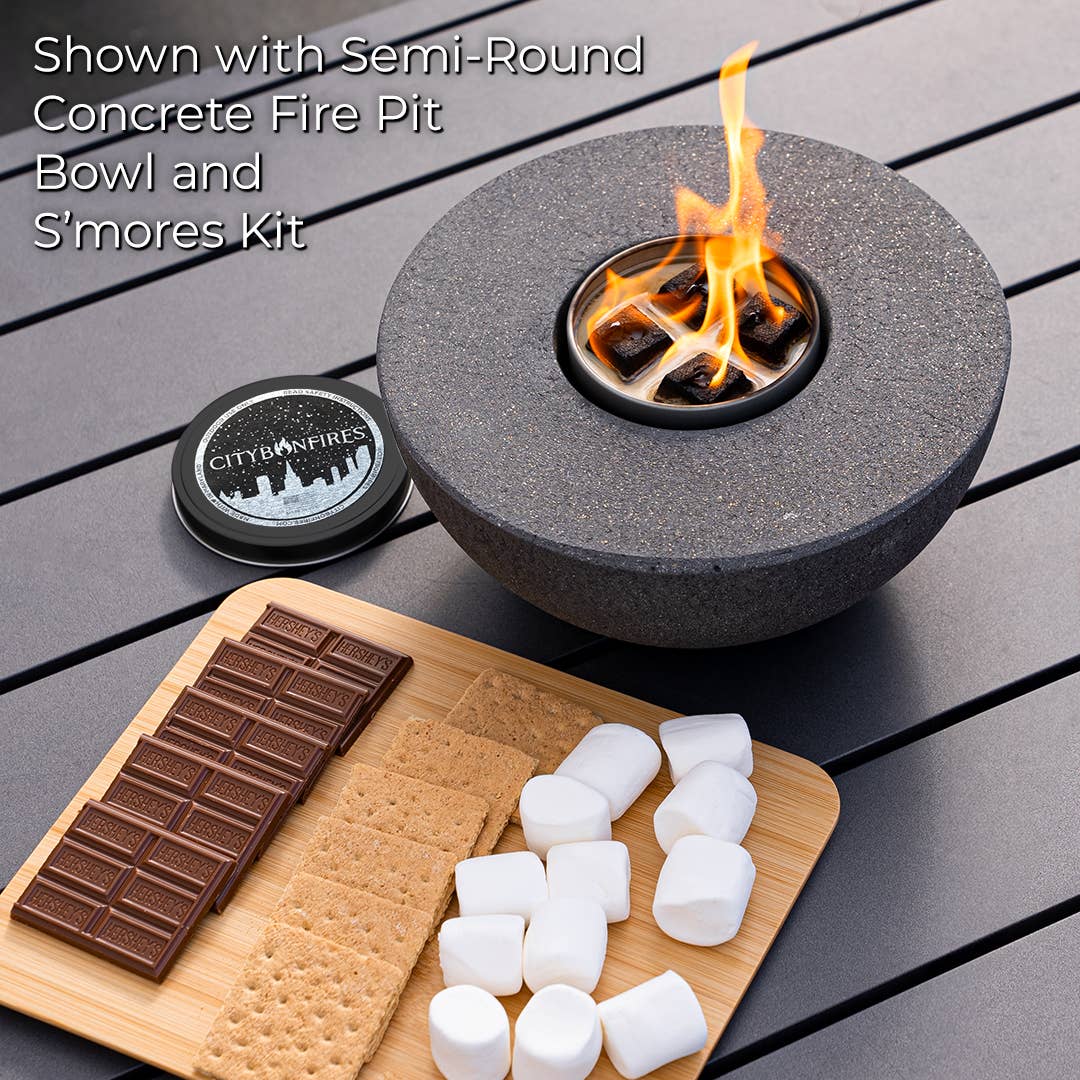 Semi-round concrete fire pit bowl with flames, surrounded by s'mores ingredients on a wooden board.