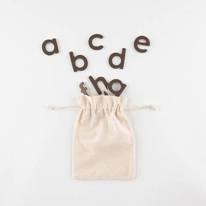 Beige drawstring bag with wooden letters on a white background