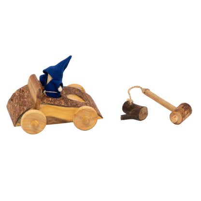 A rustic wooden toy car with a small blue gnome figurine inside, shown on a clean white background with a small wooden mallet and peg for the gnome.