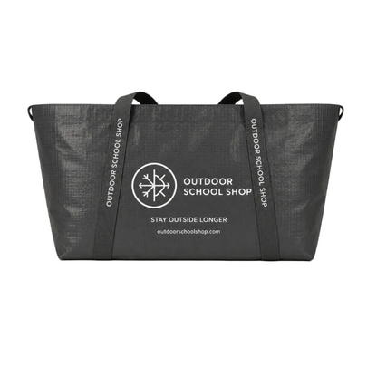 Black tote bag with 'Outdoor School Shop' branding and measurements on a beige background