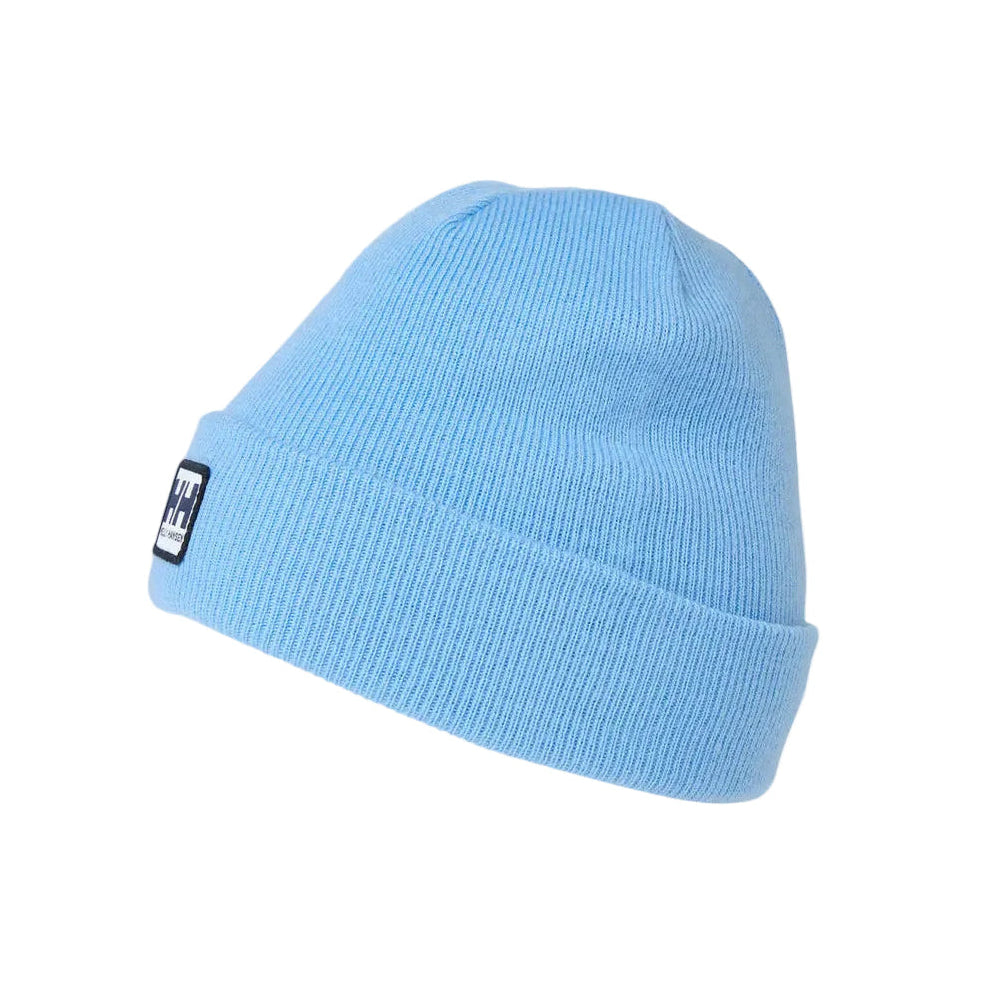 A light blue ribbed knit beanie hat with a small black and white logo patch on the folded cuff, shown against a plain light gray background.