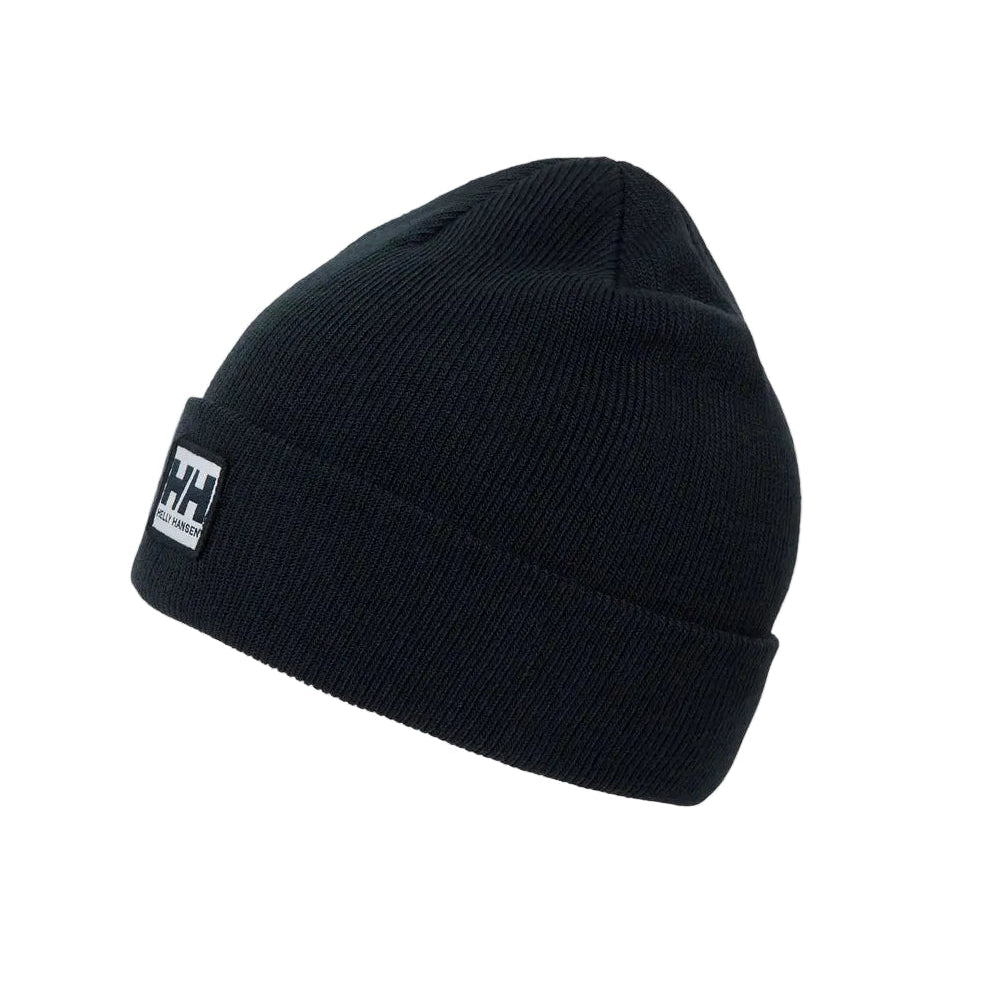 A navy ribbed knit beanie hat with a small white and black Helly Hansen logo patch on the front cuff, shown against a light gray background.