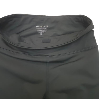 Close-up of a dark black athletic leggings waistband with the ATHLETA brand name printed inside the waistband.