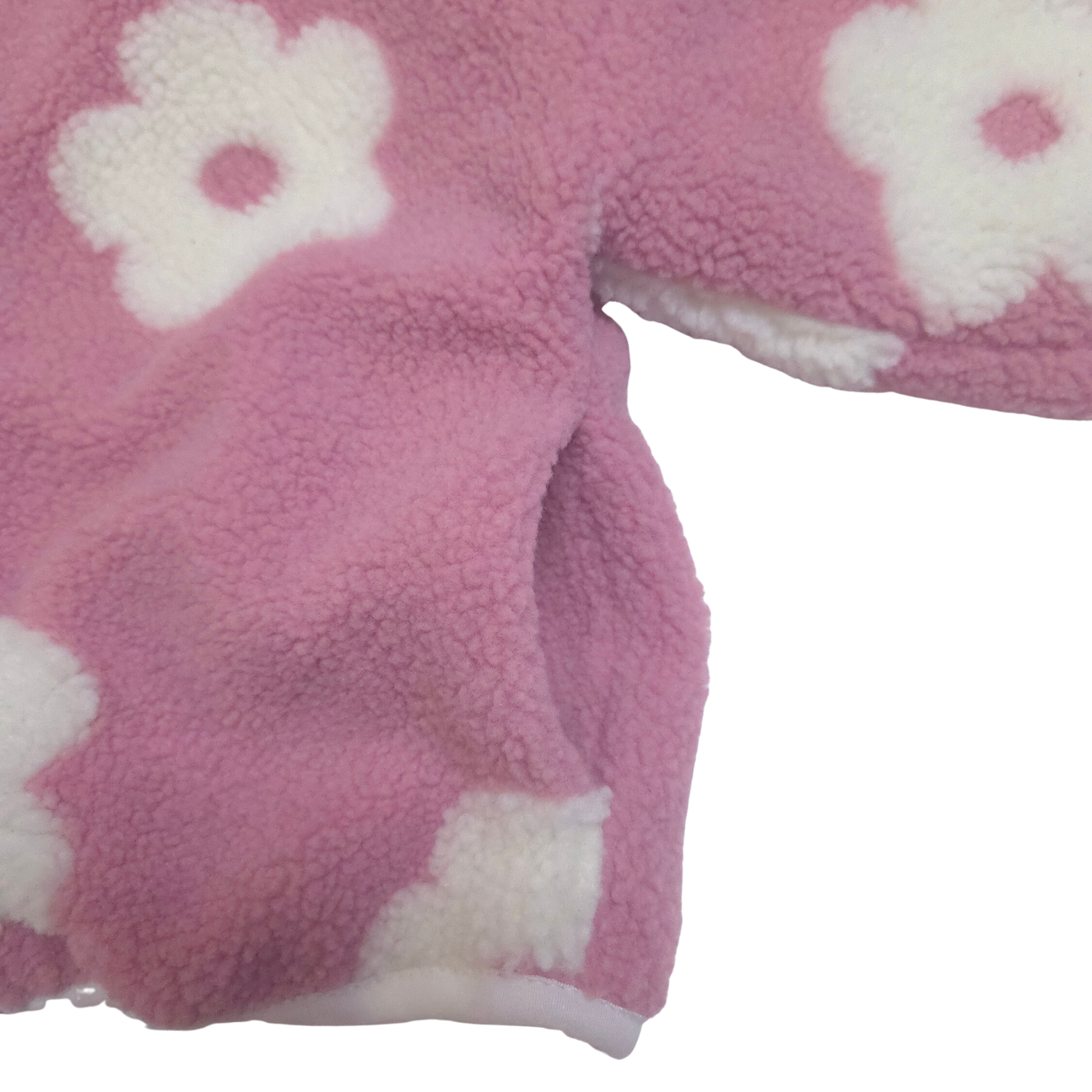 Close-up of pink fleece fabric with white flower patterns