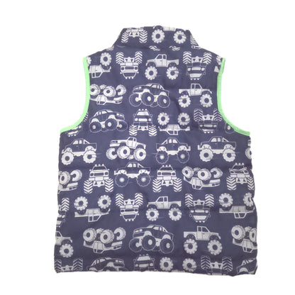 A sleeveless quilted vest with a dark blue background covered in a white monster truck, featuring bright lime green trim along the inner edges.