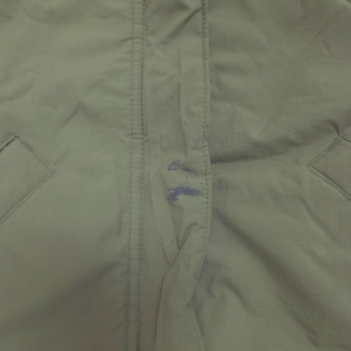 An olive green hooded puffer jacket stains