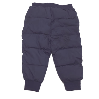 A pair of dark navy blue puffer pants with horizontal quilting, elastic waistband, and ribbed ankle cuffs back image.
