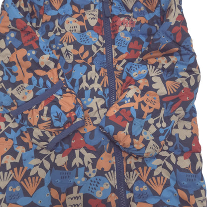 A close-up of a children's puffer suit fold-over mitts featuring a colorful, playful pattern of cartoon owls, fish, and leaves in shades of blue, orange, red, and beige on a dark navy background. 