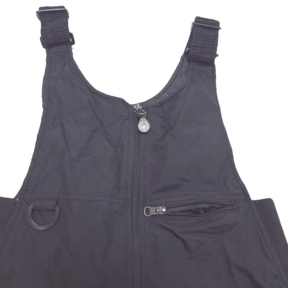 Black insulated bib snowpants showing detail of packet and hook.