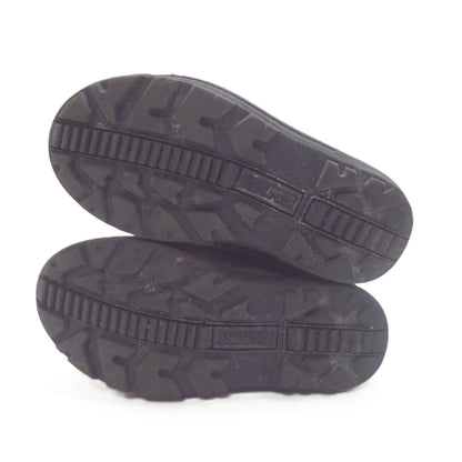 Two black rubber shoe soles shown from the bottom, displaying deep tread patterns and a textured outsole design, set against a plain white background.