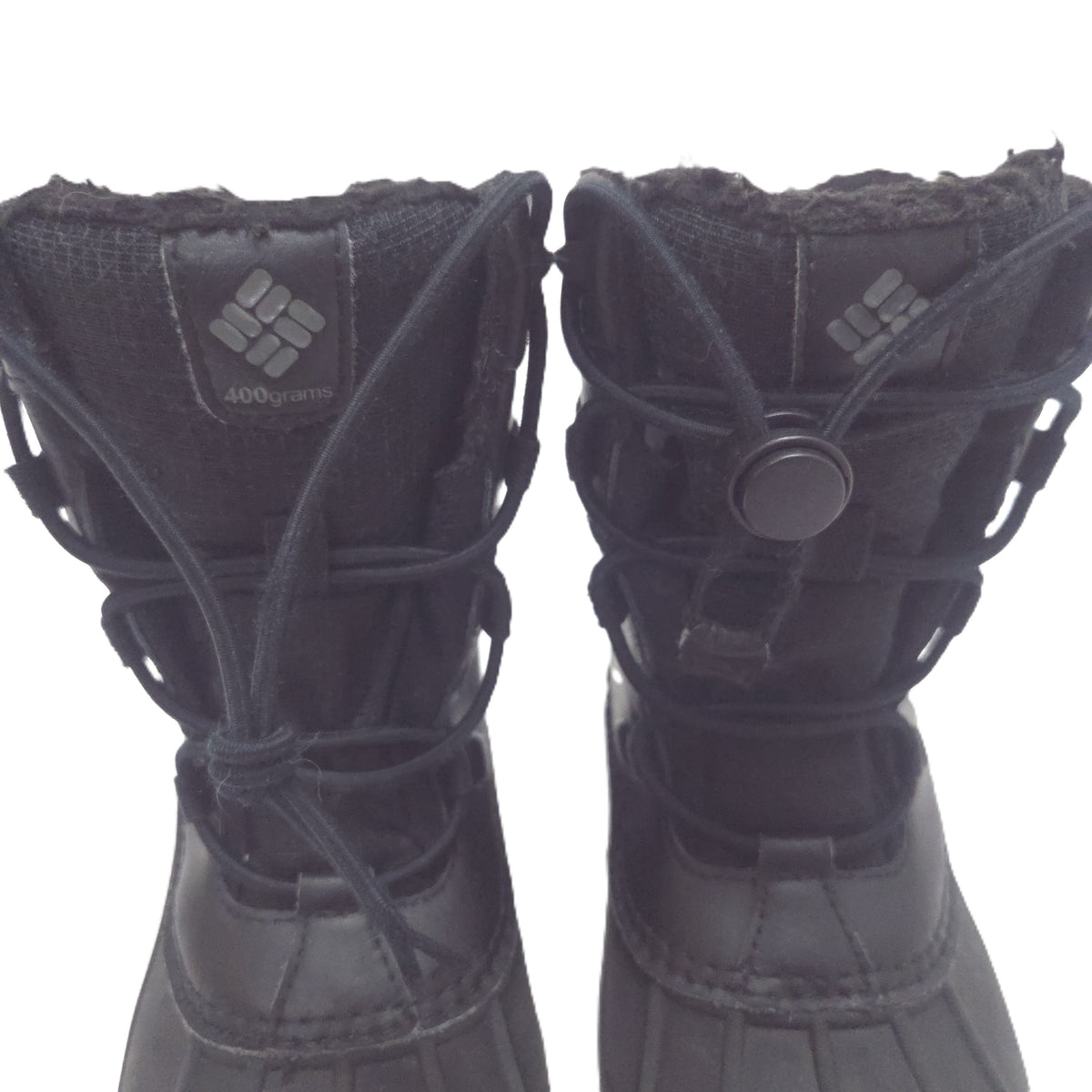 A pair of black Columbia snow boots missing one Bungee closure system shown against a plain white background.