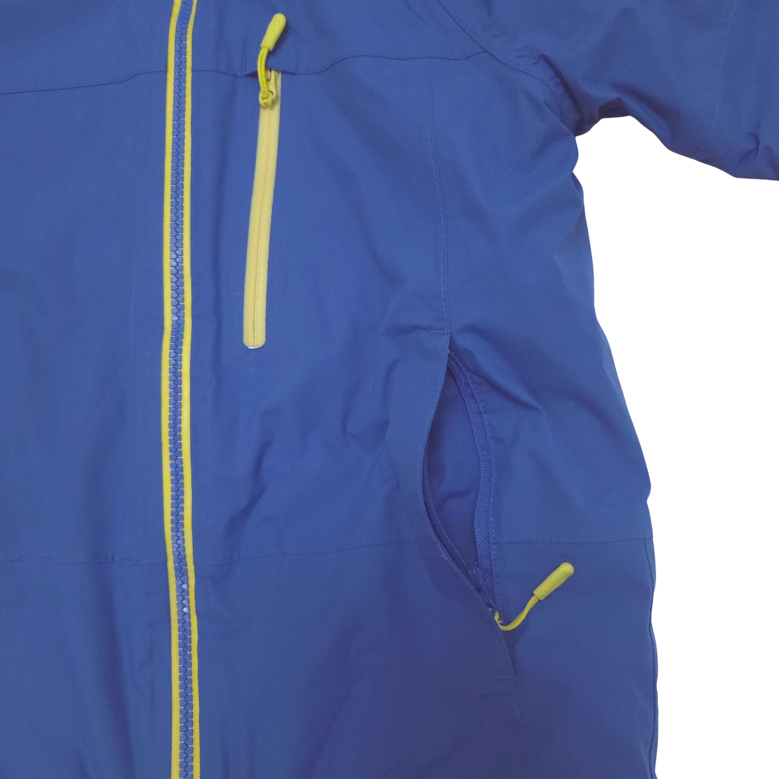 Close-up of a royal blue jacket with bright yellow zipper waist pocket and a yellow vertical zipper chest pocket.