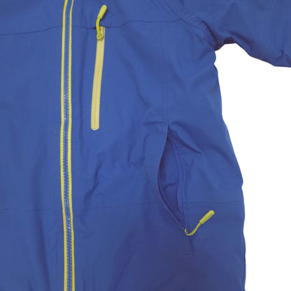 Close-up of a royal blue jacket with bright yellow zipper waist pocket and a yellow vertical zipper chest pocket.