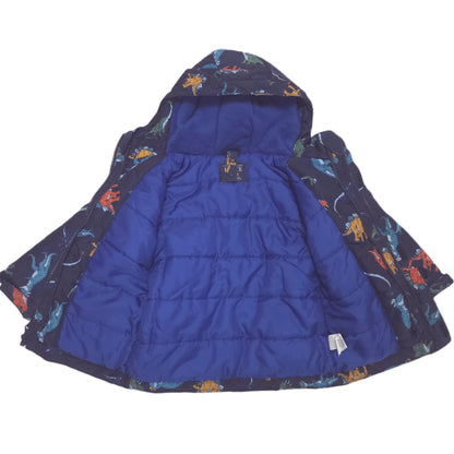 A children's hooded winter jacket in navy blue with an allover colorful dinosaur print with a royal blue quilted interior lining, shown against a plain white background.