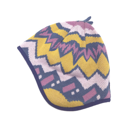 A reversible knitted beanie hat featuring a colorful chevron and geometric pattern in yellow, navy blue, pink, and white, with a solid navy blue trim side image