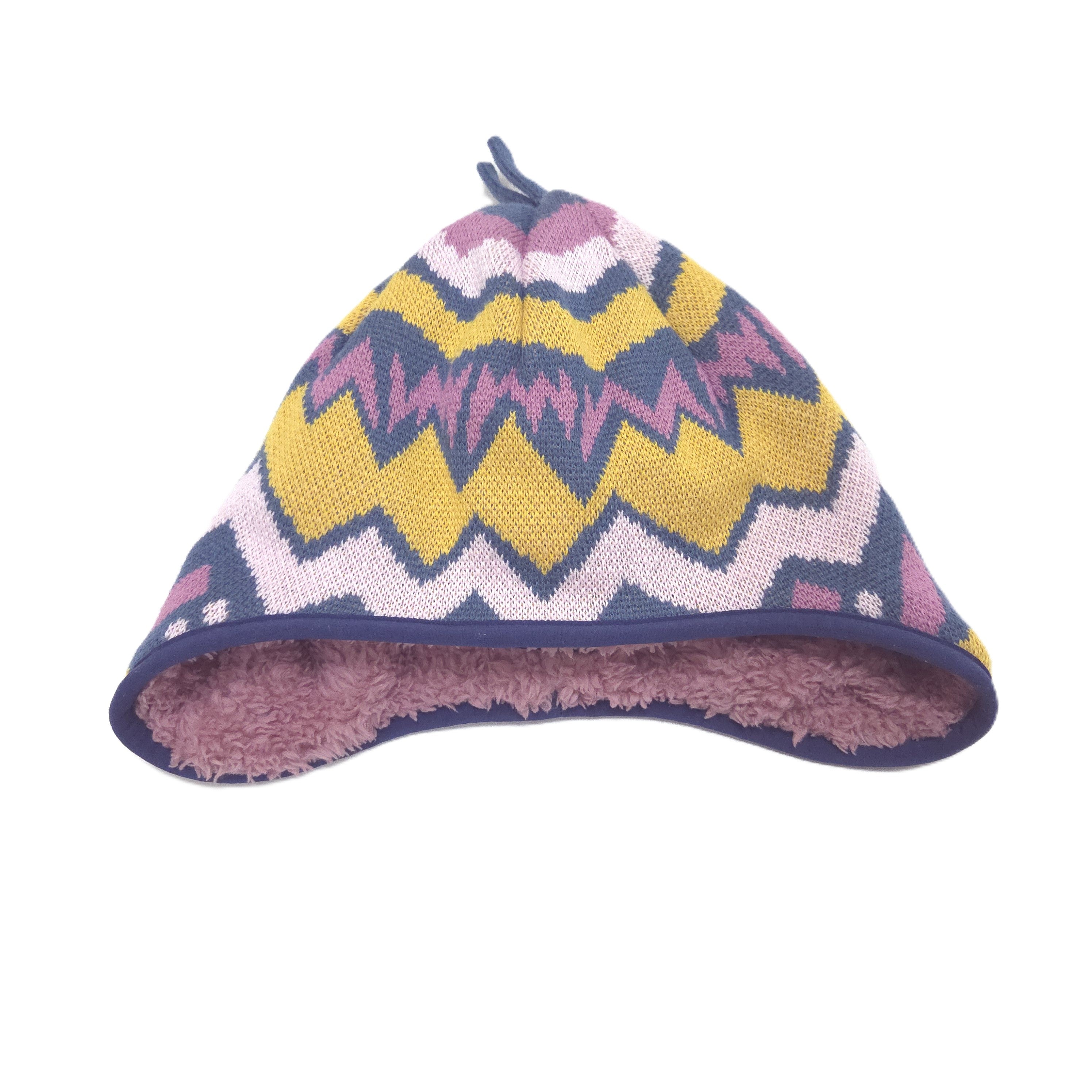 Reversible a knit beanie hat with a colorful geometric zigzag pattern in yellow, pink, purple, and white, featuring a soft pink fleece lining and a small top loop.