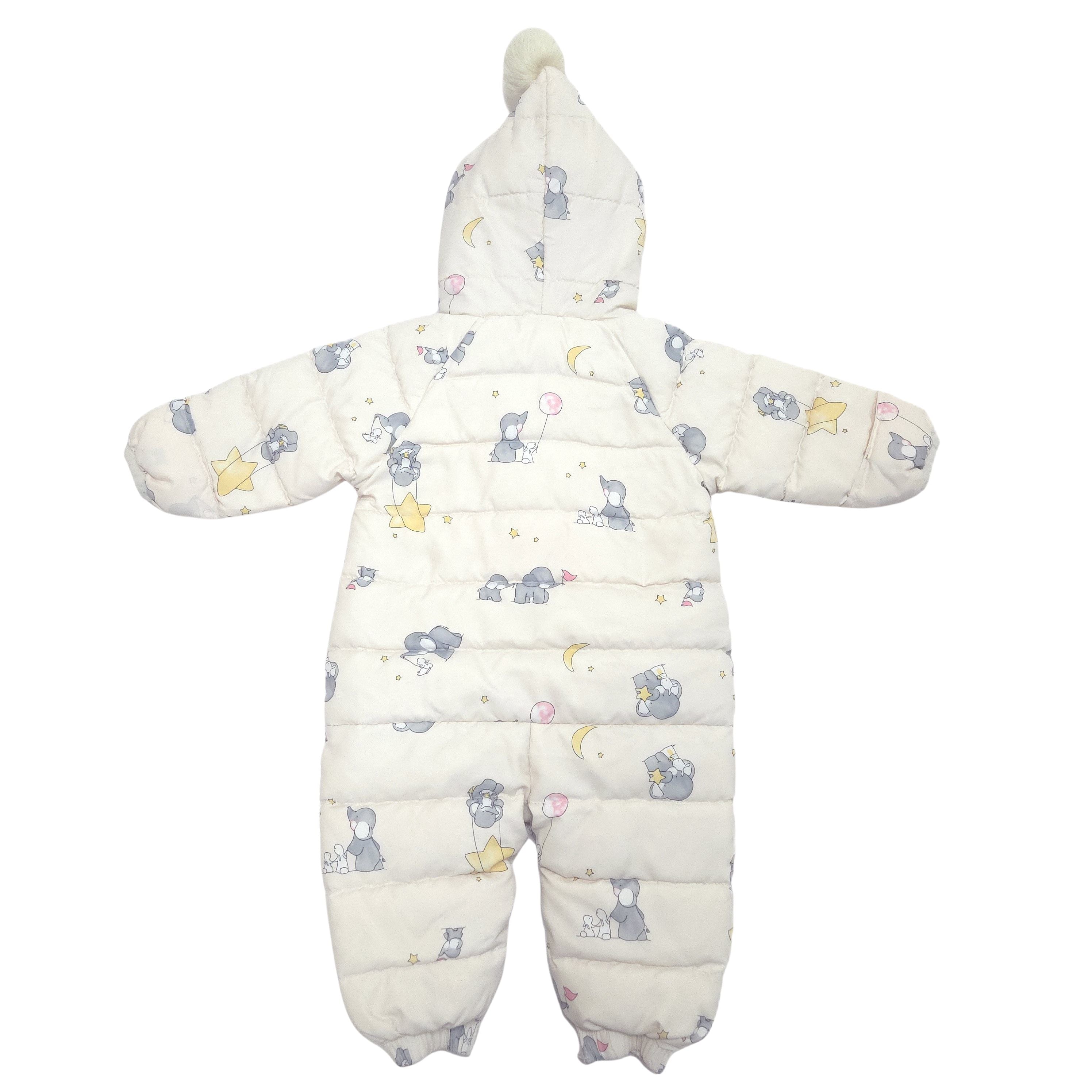 A baby puffer snowsuit in off-white with a cute print of gray elephants, yellow stars, and pink crescent moons, featuring a hood with a pom-pom.