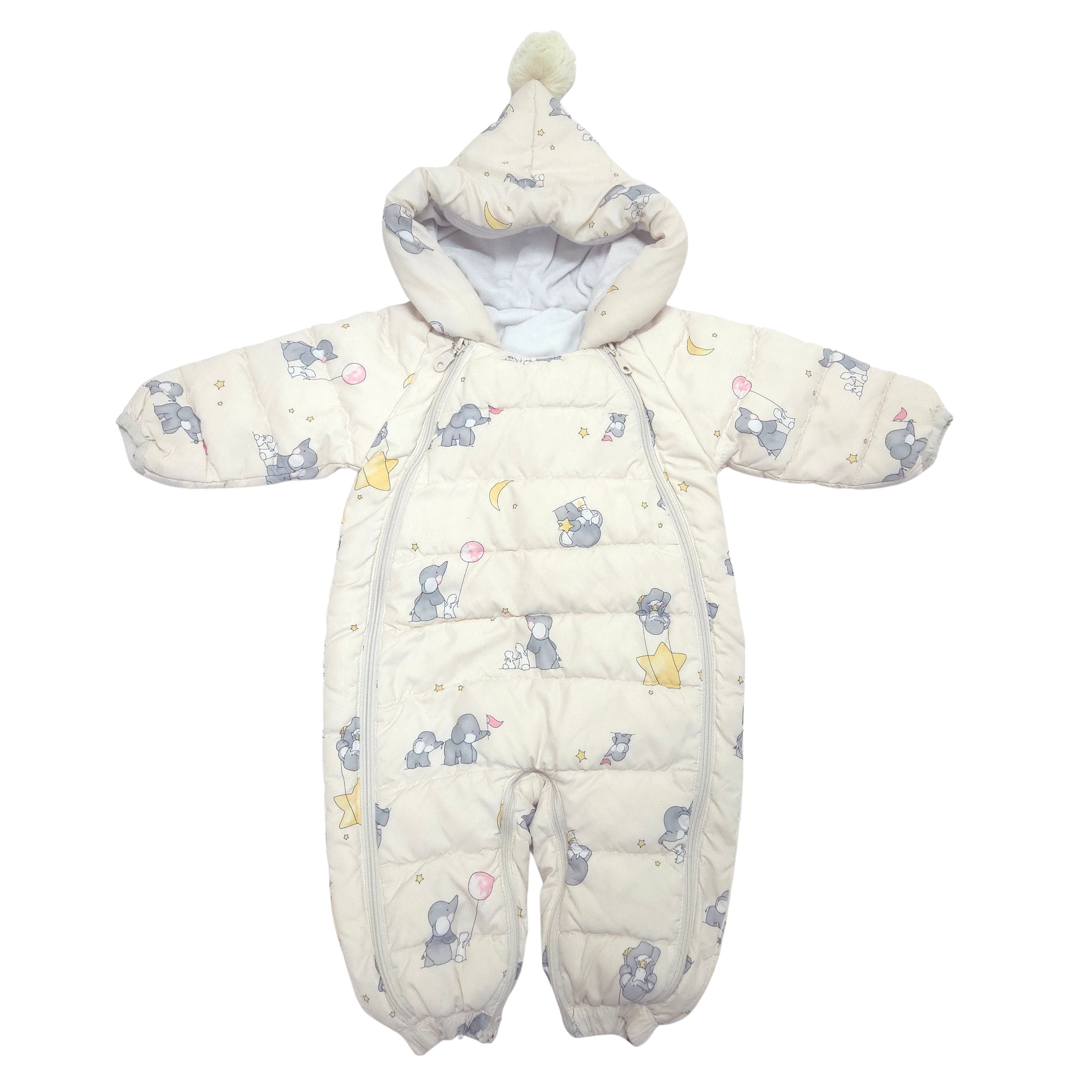 A baby snowsuit with a hood and pom-pom, featuring a light cream background with a print of blue-gray elephants, yellow stars, and crescent moons, shown against a plain white background.