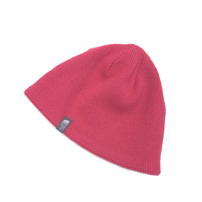 A pink knit beanie hat with a small black and white The North Face logo patch on the side, displayed on a clean white background.