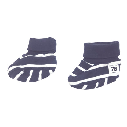 A pair of baby booties in navy blue and white stripes, and a small white brand label on the side.
