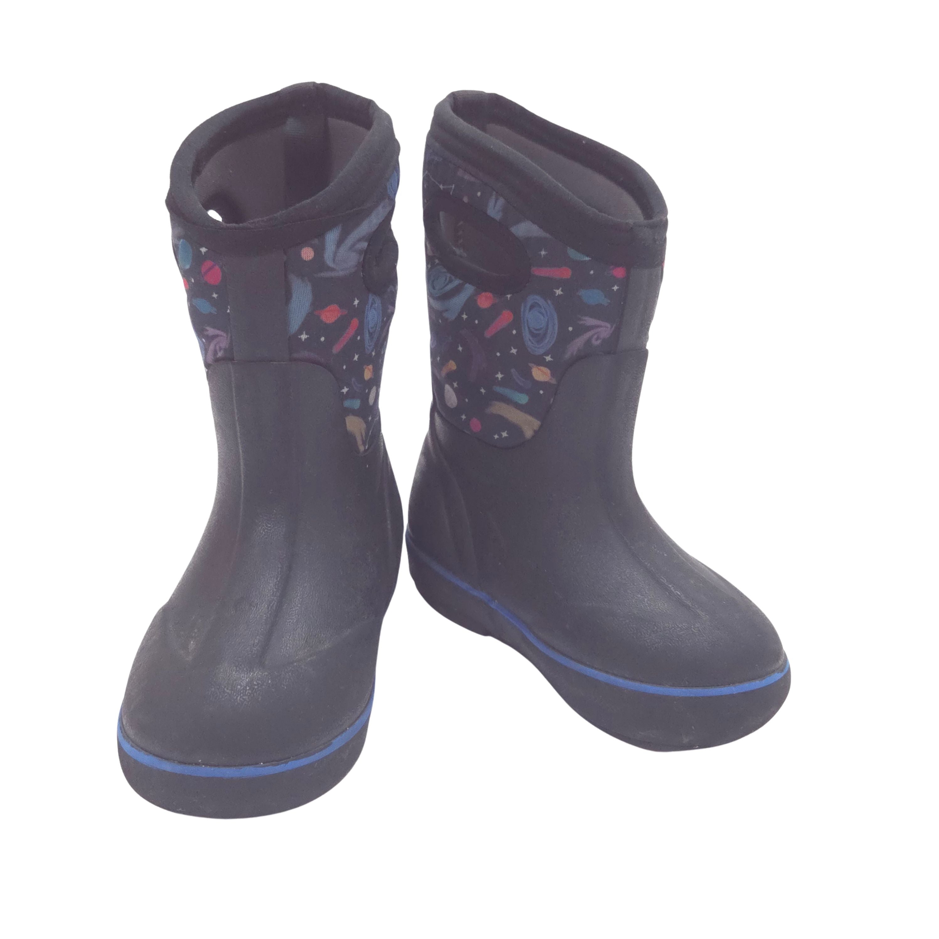 A pair of black waterproof boots with a colorful space-themed print on the side panels and a thin blue stripe along the sole, shown against a plain white background.