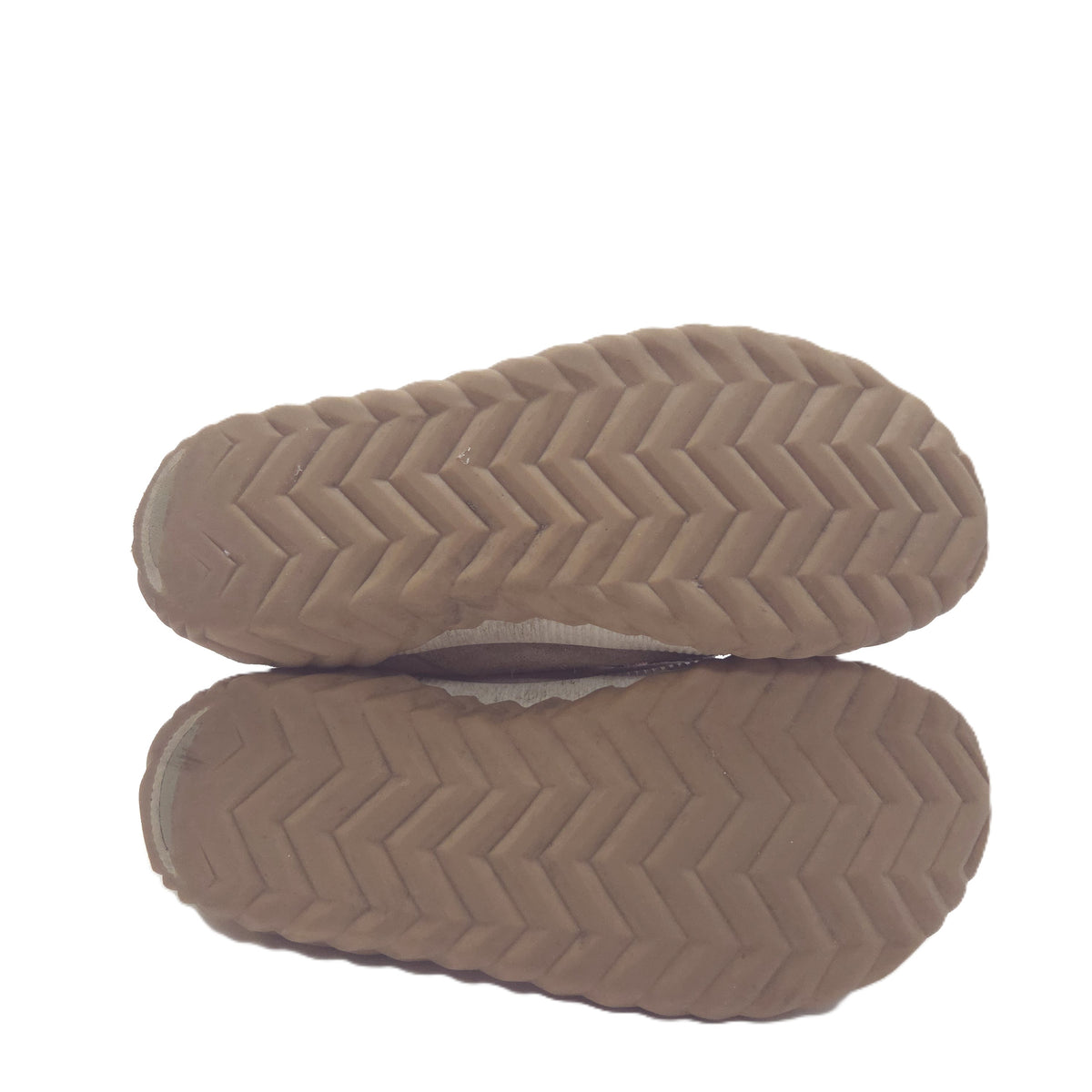 A close-up of a tan rubber shoe sole with a herringbone tread pattern, shown against a white background with a soft reflection below.