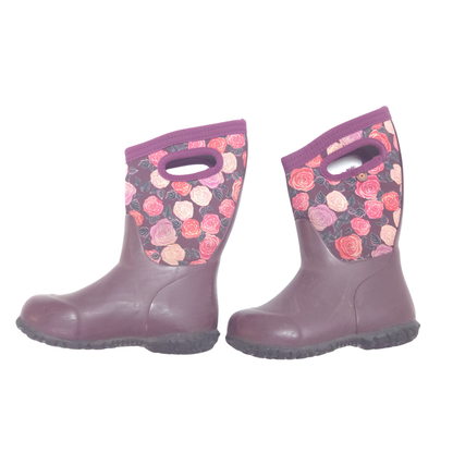 A pair of children's rain boots in a muted plum purple color, featuring a floral patterned fabric collar with pink and red roses on a dark background.