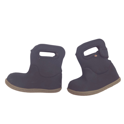 A pair of black neoprene boot covers with built-in handles and tan soles, shown against a plain white background.