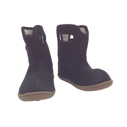 A pair of black ankle boots with a textured suede-like finish, featuring a cutout detail on the side and a light-colored lining, shown against a plain white background.