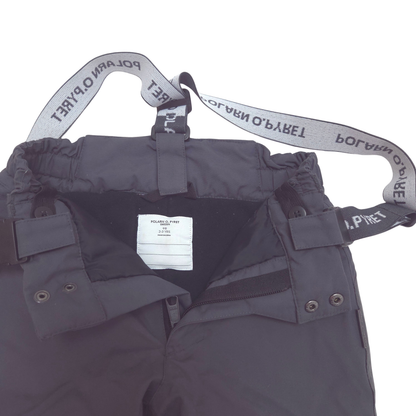 Close-up of a dark gray snow pants showing the inner waistband with elastic straps and a white brand label that reads POLAR O'PYRETT.