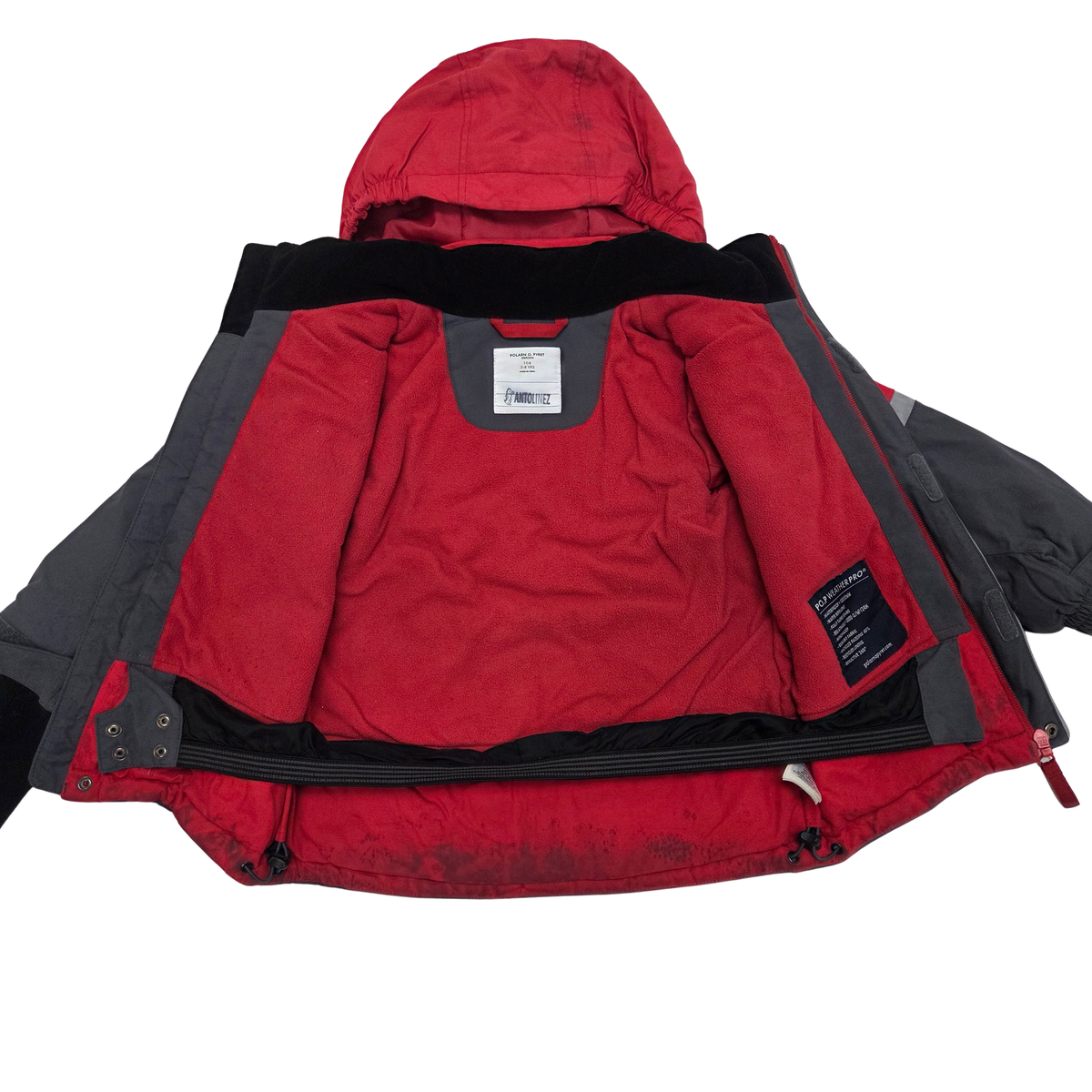 A red and dark gray hooded jacket shown open against a white background, displaying the red quilted interior lining, black collar trim, and a black interior label patch.