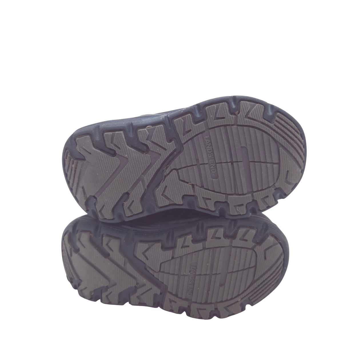 The sole view, highlighting their deep lugs and textured tread pattern against a plain white background.