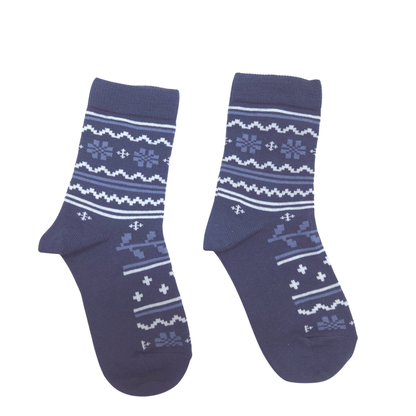 A pair of navy blue crew socks with a white and light blue Nordic/Fair Isle pattern featuring snowflakes, stripes, and geometric motifs, displayed against a solid white background.