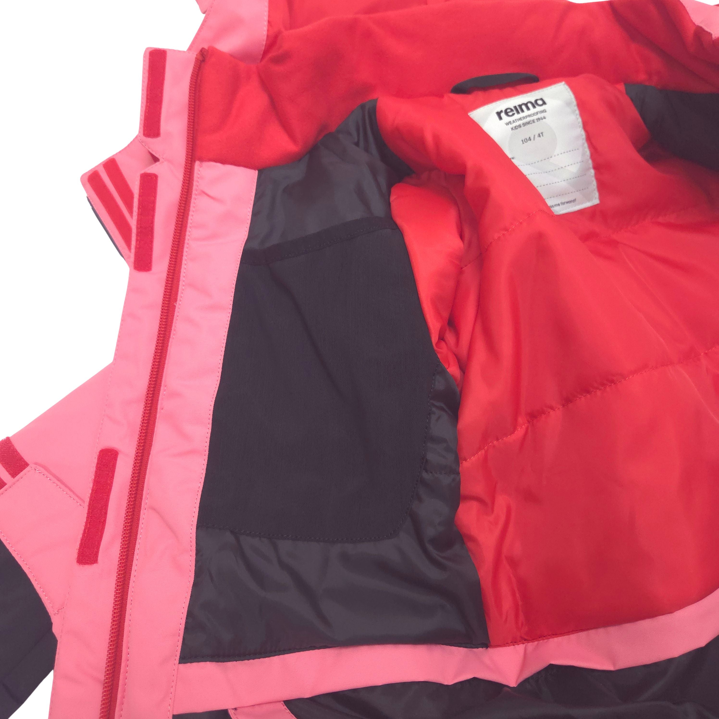 A close-up of a Reima winter jacket showing the large internal drop-in mesh pocket
