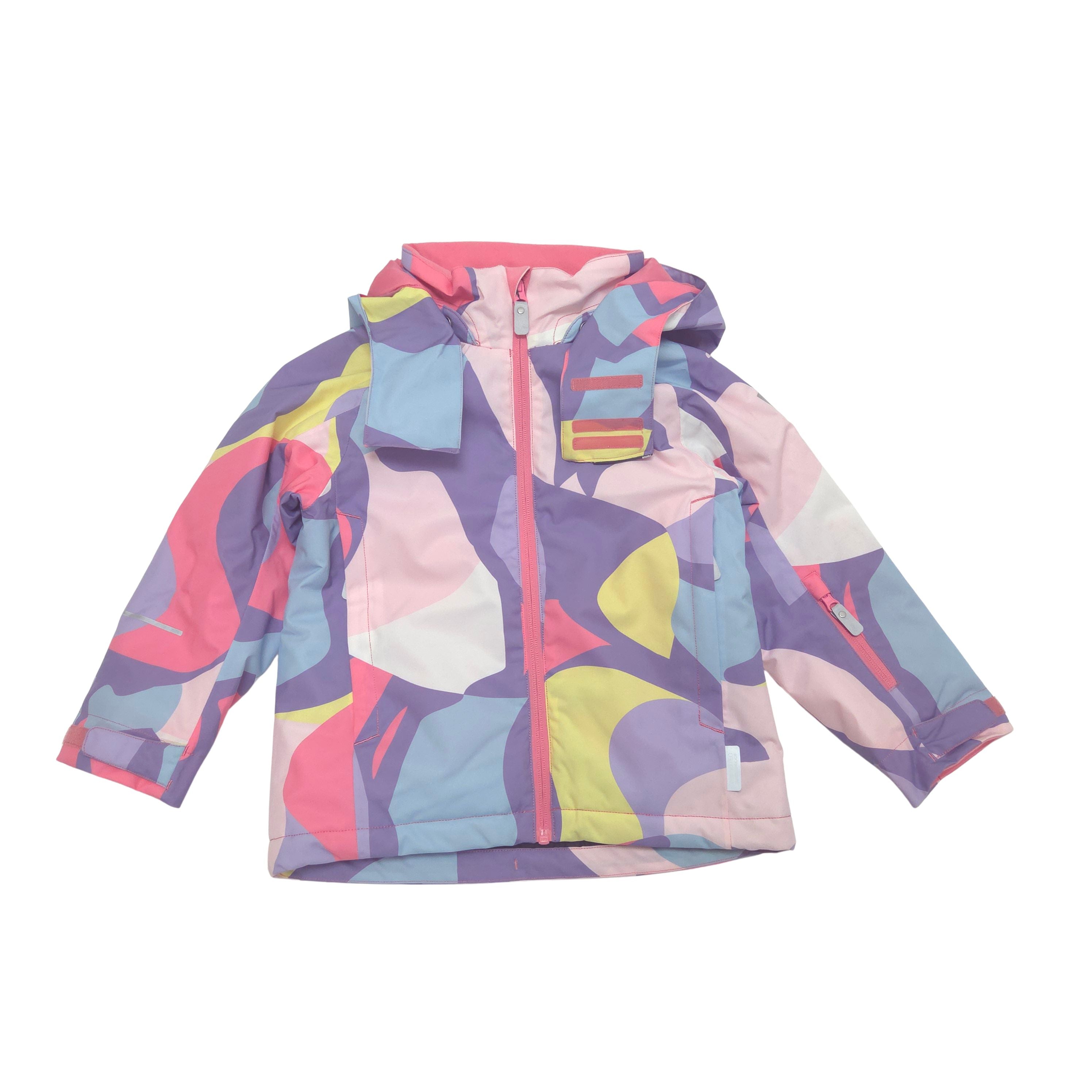 A children's hooded winter jacket with a colorful abstract geometric pattern in pink, purple, blue, yellow, and white, featuring a front zipper and zippered chest pocket, shown on a plain white background.