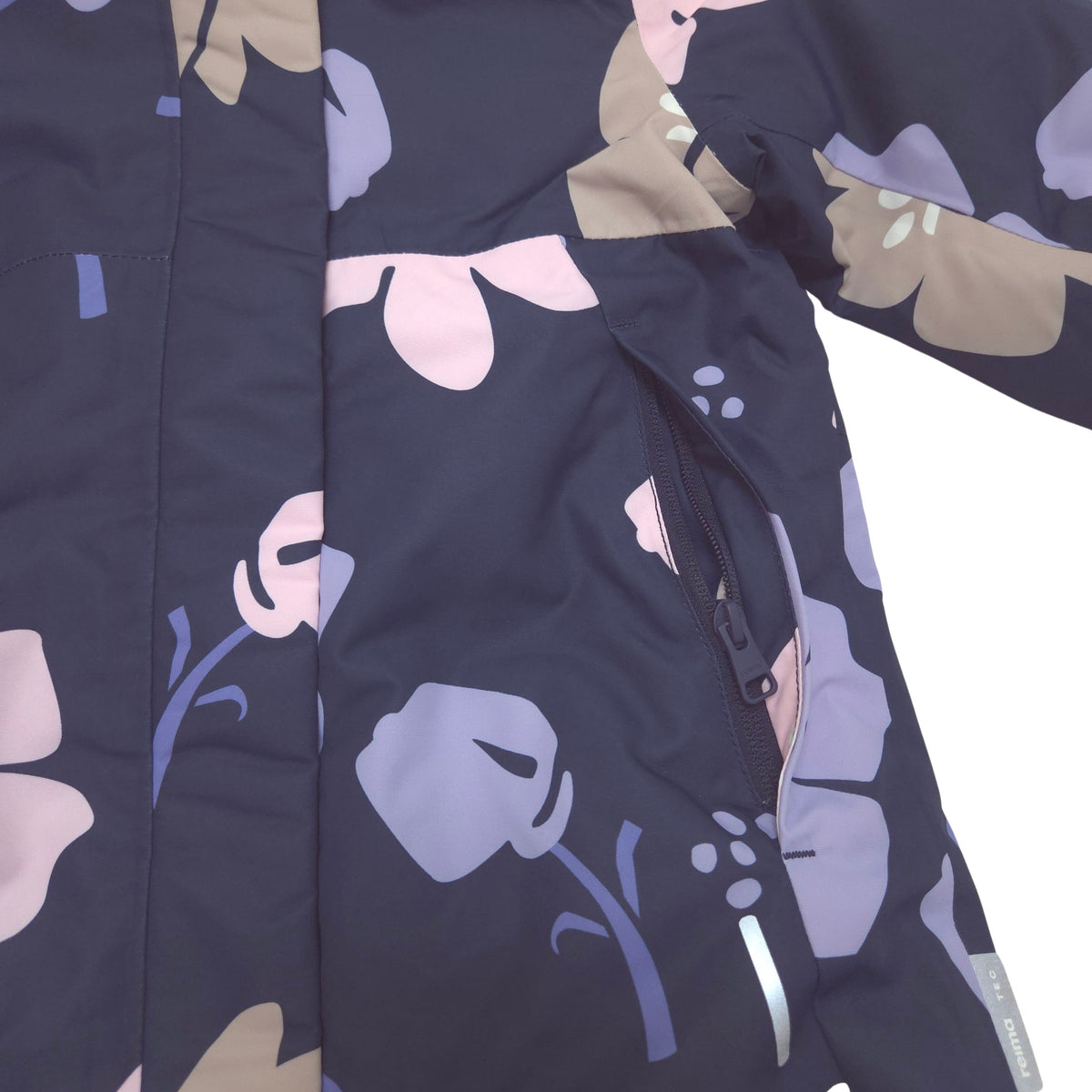 Close-up of a dark navy jacket with a floral pattern in lavender, light pink, and beige, featuring a zippered hand pocket.