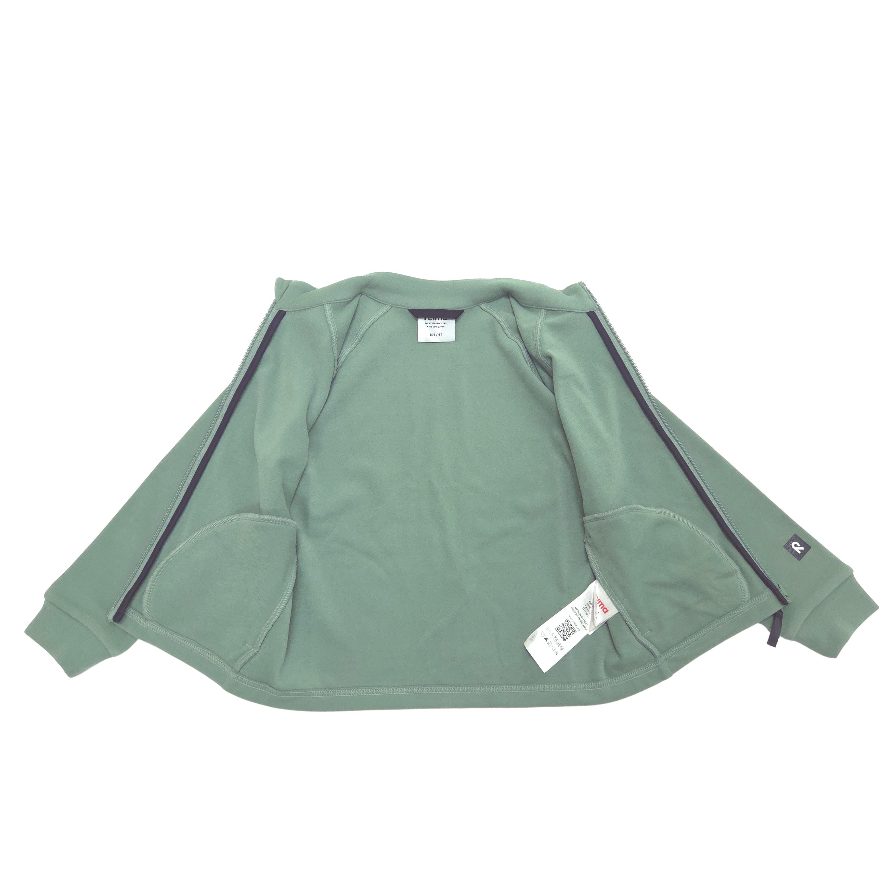 A sage green zip-up jacket with black piping along the shoulders and sleeves, laid flat on a white background with tags attached.