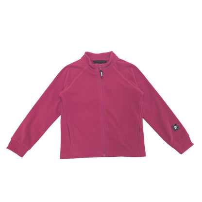 A kids' long-sleeve zip-up fleece jacket in a red color, laid flat against a solid white background. The jacket features a mock neck, a full-length front zipper, zippered hand pockets, and a small black brand patch on the left sleeve cuff.