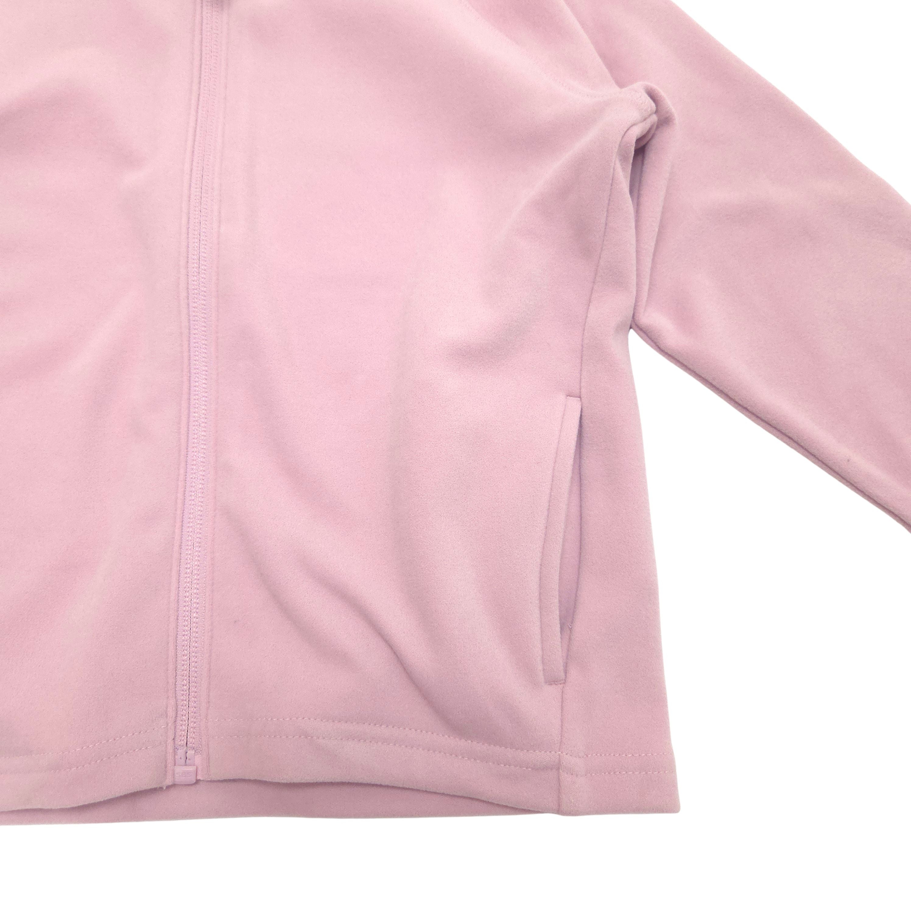 A close-up of a light pink zip-up jacket, showing the fabric texture, a front zipper, and a side pocket on a plain white background.